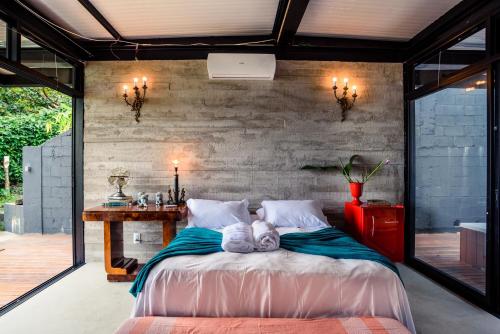 a bedroom with a bed with a teddy bear on it at Vila Bambu Ilhabela, Santa Tereza in Ilhabela