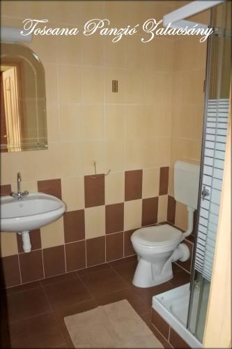 a bathroom with a toilet and a sink at Toscana Panzió in Zalacsány