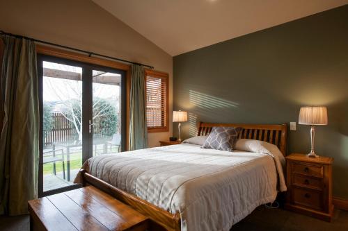 a bedroom with a bed and a large window at Wanaka Luxury Apartments in Wanaka