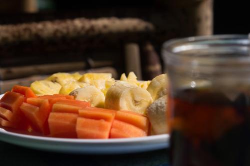 a plate of vegetables on a table with a drink at Ina Gili Guesthouse in Gili Air