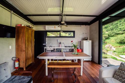 a kitchen with a table in a tiny house at Vila Bambu Ilhabela, Santa Tereza in Ilhabela