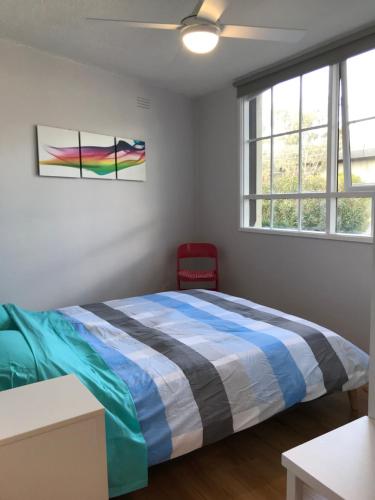 a bedroom with a bed and a window at Santa Monica Apartment in Carnegie