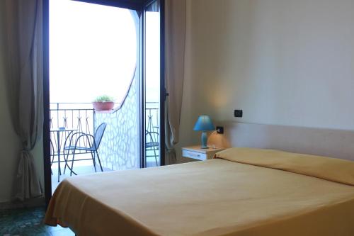 a hotel room with a bed and a balcony at Hotel Palinuro in Palinuro