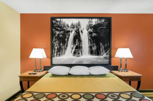 a hotel room with a bed with two lamps at Super 8 by Wyndham Chico in Chico