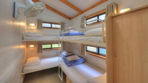 Zimmer mit 4 Etagenbetten in einem Haus in der Unterkunft Yea Riverside Caravan Park in Yea
