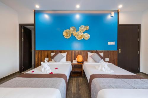 two beds in a room with a large screen at December Hoi An Villa in Hoi An