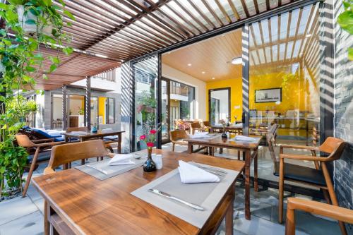 a restaurant with wooden tables and chairs at December Hoi An Villa in Hoi An