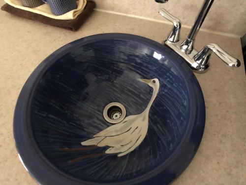 a bathroom sink with a painting of a bird on it at Wheeler on the Bay Lodge and Marina in Wheeler