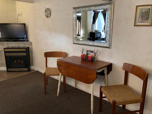 a living room with a table and chairs and a mirror at Wheeler on the Bay Lodge and Marina in Wheeler