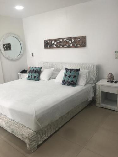 a bedroom with a large white bed with two pillows at Le Castel Blanc Hotel Boutique in San Andrés