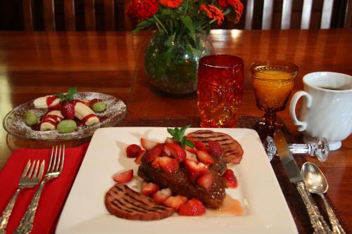 a plate of food with strawberries on a table at Eureka Street Inn in Sutter Creek