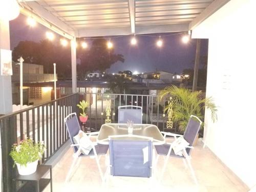 a patio with a table and chairs on a balcony at night at M/H HOUSE (#2) cozy house near airport and beach in Carolina