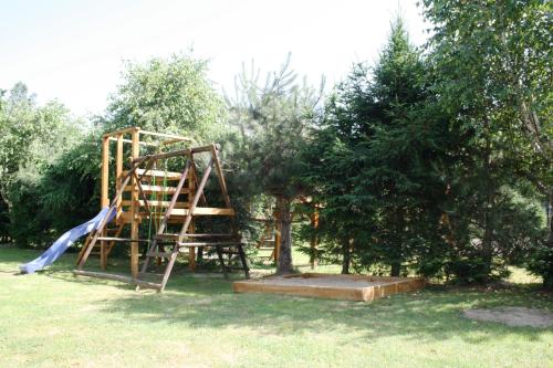 un parque infantil con un tobogán y un manzano en Domki w Bieszczadach en Polańczyk