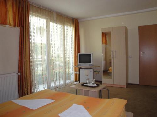 a hotel room with a bed and a television at Suri Guesthouse in Braşov