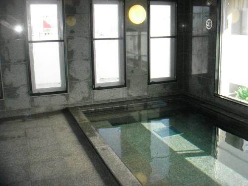 a pool of water in a room with windows at Hotel Route-Inn Miyazaki Tachibana Dori in Miyazaki