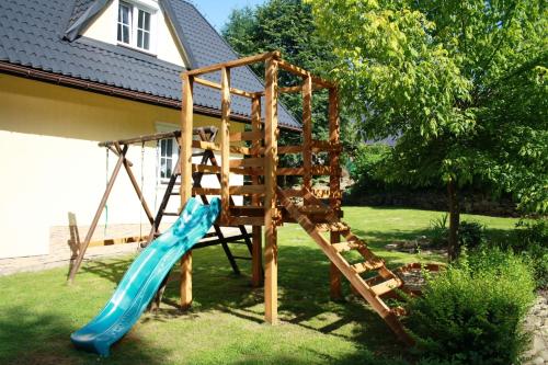 a playground with a blue slide in a yard at Dom Aga Bieszczady 10 osobowy in Bukowiec