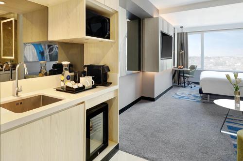 a kitchen and living room in a hotel room at Novotel Suites Yogyakarta Malioboro in Yogyakarta