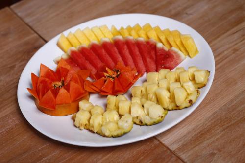a white plate with fruit on a wooden table at Sutera at Mantanani Island Resort & Spa in Mantanani Island 