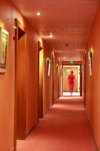 a woman walking down a corridor in a hallway at Hotel de la Jamagne & Spa in Gérardmer