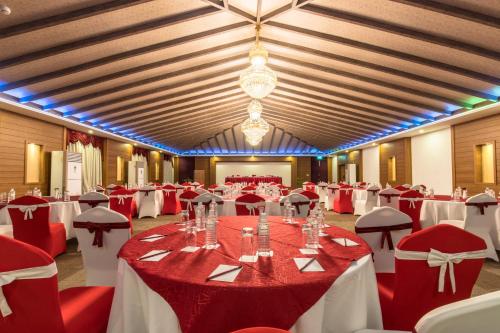 a banquet hall with red and white tables and chairs at Mountain Glory Forest Resort in Pokhara