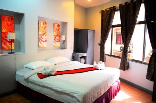 a bedroom with a large bed and two windows at Best Corner Pattaya in Pattaya South