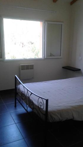un lit dans une chambre avec une grande fenêtre dans l'établissement Casapiana 08, à Porto-Vecchio