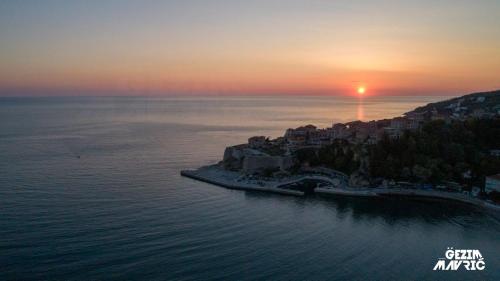 an island in the middle of the ocean with a sunset at Padam Hotel & SPA in Ulcinj