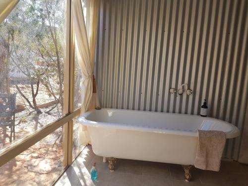 a bath tub in a bathroom with a window at Ooraminna Homestead in Alice Springs