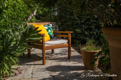 a chair with colorful pillows sitting on a patio at Hotel Les Restanques De Moustiers in Moustiers-Sainte-Marie