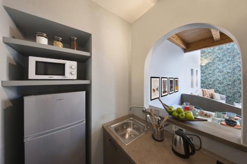 a kitchen with a sink and a microwave at Amore Rentals - Casa La Maisonette in Sorrento