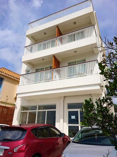 a white building with cars parked in front of it at Little Piggy B&B in Manzhou