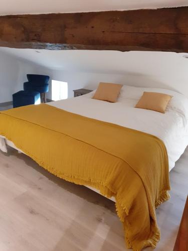 une chambre avec un grand lit avec une couverture jaune dans l'établissement A Casetta di SANTA MARIA, à Furiani