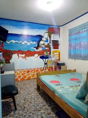a bedroom with a bed and a painting on the wall at Bolo Beach Santorini nearby to Hundred Island in Alaminos