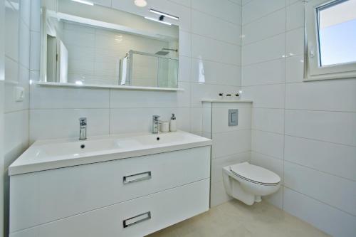 a white bathroom with a sink and a toilet at FAMILY VILLA WITH POOL-Peaceful Hvar Island Oasis in Bogomolje