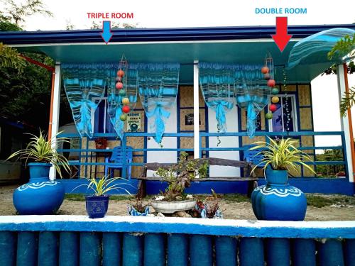 a building with three blue pots with plants in it at Bolo Beach Santorini nearby to Hundred Island in Alaminos