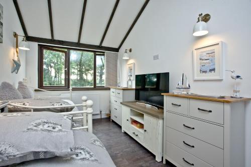 a bedroom with a bed and a desk and a tv at The Barn in Lanhydrock, Bodmin in Bodmin