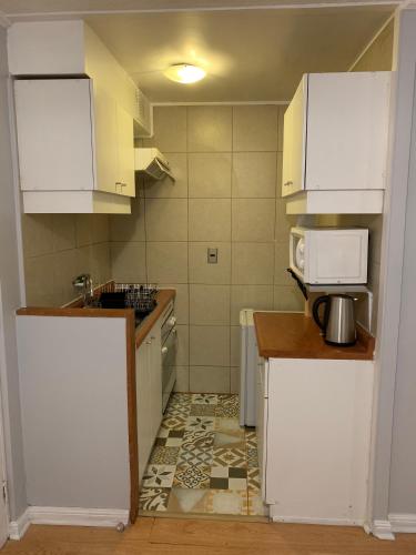 a small kitchen with white cabinets and a tile floor at Stay Santiago Lastarria Bellas Artes in Santiago