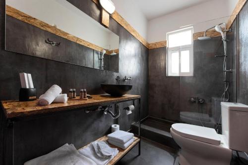 a bathroom with a sink and a toilet at Piraeus Premium Suites in Piraeus