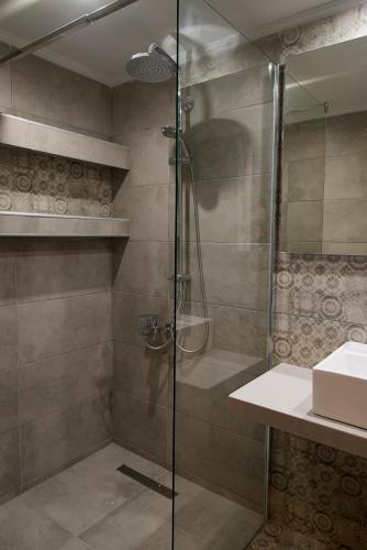 a shower with a glass door in a bathroom at Compass beach in Stalís
