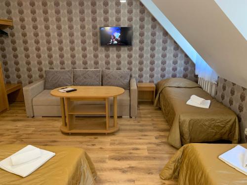 a room with two beds and a table and a couch at Raze in Palanga