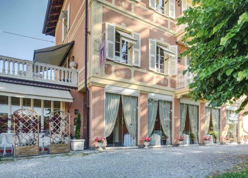 różowy budynek z oknami i balkonem w obiekcie Duchessa Margherita Chateaux & Hotels w mieście Vicoforte