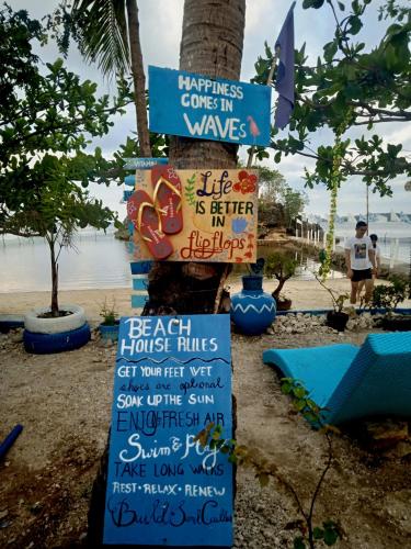 a sign on a beach with signs on it at Bolo Beach Santorini nearby to Hundred Island in Alaminos