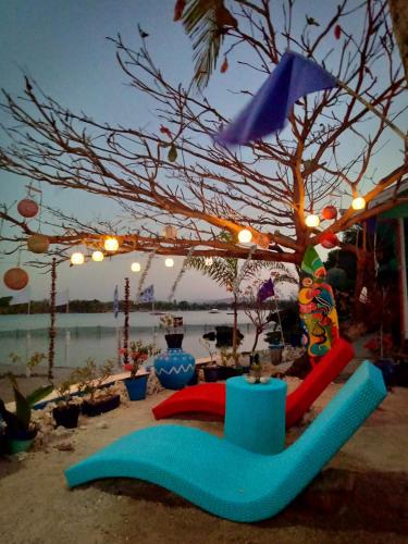 a beach with a table and an umbrella and a tree at Bolo Beach Santorini nearby to Hundred Island in Alaminos