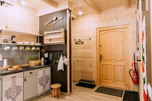 a kitchen with wooden walls and a wooden door at Czarna Owca in Kościelisko