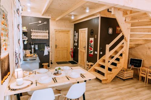 a dining room with a wooden table and stairs at Czarna Owca in Kościelisko