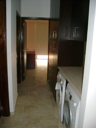 a hallway of a kitchen with a washer and dryer at Starlit Villa in Kathikas