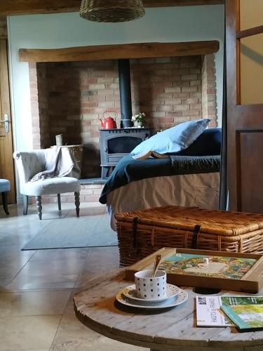 Habitación con cama, mesa y chimenea. en Le Clos de Marenla, en Marenla