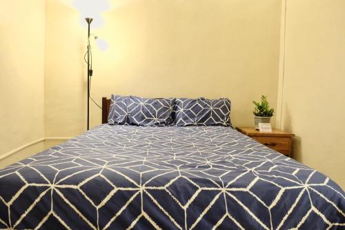 a bedroom with a bed with a blue and white comforter at Coron Residencia de Rosario in Coron