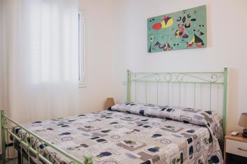 Una cama con edredón en un dormitorio en Milva's Apartment, en Lotzorai