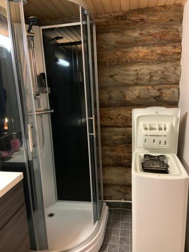 uma casa de banho com um chuveiro e uma máquina de lavar e secar roupa em Rukankuukkeli b13 em Kuusamo
